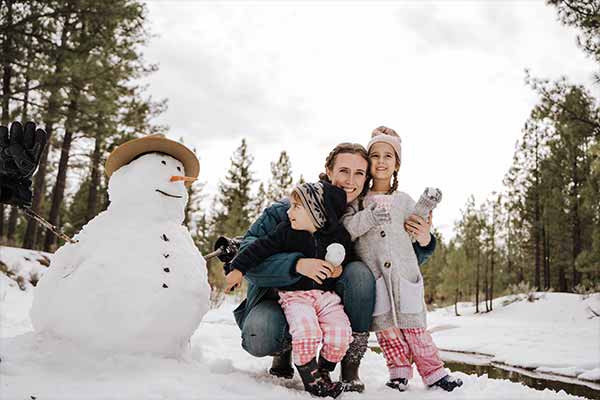 Kinder, die einen Schneemann gebaut haben